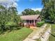 Quaint ranch home with stone exterior and tree-lined driveway at 290 Valencia Rd, Debary, FL 32713