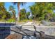 View of landscaped backyard with tropical palm trees, stone pavers, and wrought iron fence at 349 La Creek Ct, Debary, FL 32713