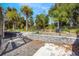 Landscaped backyard with mature palm trees, wrought iron fence, and stone block retaining walls at 349 La Creek Ct, Debary, FL 32713