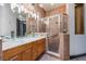 Modern bathroom featuring glass vessel sinks, white countertops, wooden cabinets, and a glass-enclosed shower at 349 La Creek Ct, Debary, FL 32713