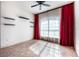 Bright bedroom featuring a ceiling fan, tile flooring, a large window with red curtains, and decorative floating shelves at 349 La Creek Ct, Debary, FL 32713