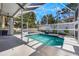 Screened-in pool area with sunny patio, waterfall feature, and view to the back yard at 349 La Creek Ct, Debary, FL 32713