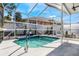 Screened-in pool area with sunny patio, waterfall feature, and well-manicured landscaping at 349 La Creek Ct, Debary, FL 32713