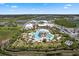 Aerial view of a Primary planned community featuring a large pool, palm trees, and mature landscaping at 583 Good Life Way, Daytona Beach, FL 32124