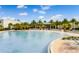 Expansive community pool featuring abundant lounge seating and decorative palm trees on a sunny day at 583 Good Life Way, Daytona Beach, FL 32124