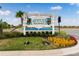 Community entrance sign decorated with holiday ornamentation and manicured landscaping and bright blue skies at 583 Good Life Way, Daytona Beach, FL 32124