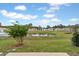 Landscaped backyard with pond views, lush greenery, and blue skies enhance the home's appeal at 203 River Front Way, Edgewater, FL 32141