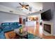 Bright living room featuring a fireplace, wooden floors, ceiling fan, and open kitchen concept at 337 Goldstone Pl, Lake Mary, FL 32746