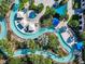 Stunning aerial view of a community pool with a lazy river, lush landscaping, and seating areas at 8844 Corcovado Dr, Kissimmee, FL 34747