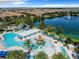 Aerial view of the resort-style pool with slides, a splash pad, lounge seating, and a beautiful lakeside setting at 8844 Corcovado Dr, Kissimmee, FL 34747