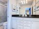 Bathroom with double sinks, white cabinetry, a shower with glass doors, and attractive decor at 8844 Corcovado Dr, Kissimmee, FL 34747