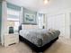 Bright bedroom with neutral walls, a plush bed, bedside tables, lamps, and white window curtains at 8844 Corcovado Dr, Kissimmee, FL 34747