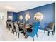 Spacious dining room with a long wooden table set for 12, blue accent wall, and modern decor at 8844 Corcovado Dr, Kissimmee, FL 34747