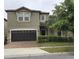 Two-story home featuring a dark-brown two-car garage, neutral paint, and meticulously manicured landscaping at 8844 Corcovado Dr, Kissimmee, FL 34747