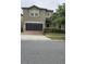 A charming two-story home with a two car garage sits on a neatly maintained lot with grass and shrubs at 8844 Corcovado Dr, Kissimmee, FL 34747