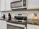 Modern kitchen features stainless steel appliances, sleek black granite countertops, and white cabinets at 8844 Corcovado Dr, Kissimmee, FL 34747
