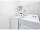 Well-lit laundry room with a white washer and dryer and a wire shelf for storage at 8844 Corcovado Dr, Kissimmee, FL 34747