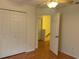 Bedroom featuring laminate wood flooring, double-door closet, and an open doorway creating an inviting and functional space at 14460 Clarkson Dr, Orlando, FL 32828