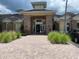 Community clubhouse with brick facade, tile roof, manicured landscaping, and accessible entrance at 14460 Clarkson Dr, Orlando, FL 32828