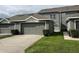 Well-maintained townhome with a gray exterior, an attached garage and manicured landscaping at 14460 Clarkson Dr, Orlando, FL 32828