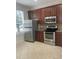 Kitchen with stainless steel appliances, brown cabinets, and tiled floor at 14460 Clarkson Dr, Orlando, FL 32828