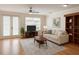 Living room with ceiling fan, sofa, TV, and built-in shelves at 14460 Clarkson Dr, Orlando, FL 32828