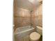 Tiled bathroom featuring a bathtub and toilet with tiled walls at 2432 Lemon Tree Ln # B, Orlando, FL 32839