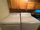 Laundry area with stacked washer and dryer, upper cabinets, and tile backsplash at 2432 Lemon Tree Ln # B, Orlando, FL 32839