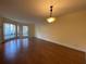 Bright living room featuring wood floors, large windows, and a modern hanging ceiling light at 2432 Lemon Tree Ln # B, Orlando, FL 32839