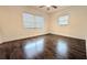 Bright bedroom with two large windows, dark wood flooring, and neutral walls at 2819 Pembrook Dr, Orlando, FL 32810