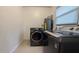 Laundry room featuring modern washer and dryer units against a tiled wall at 2819 Pembrook Dr, Orlando, FL 32810