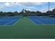 Two well-maintained blue tennis courts with green surrounding at 6147 Sunnyvale Dr, Orlando, FL 32822