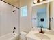 Modern bathroom with a shower over tub, single sink, and small window for natural light at 10257 Medawar St, Orlando, FL 32827