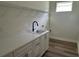 Convenient laundry room with white cabinets and a utility sink at 10257 Medawar St, Orlando, FL 32827