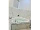 A jetted tub features white marble and grey granite trim in this soothing bathroom setting at 17271 E Peggy Ave. Ave, Mount Dora, FL 32757