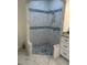 Updated bathroom features tiled walk-in shower with blue and gray accents and a pebble floor at 17271 E Peggy Ave. Ave, Mount Dora, FL 32757
