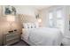 Bright bedroom features a tufted headboard, bedside tables with lamps, and a door leading to a balcony at 7554 Marker Ave, Kissimmee, FL 34747