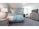 Comfortable bedroom features a queen-sized bed, stylish decor, and an entertainment center at 7554 Marker Ave, Kissimmee, FL 34747