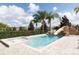 A private pool includes a spa and rock slide surrounded by palm trees for the ultimate vacation experience at 7554 Marker Ave, Kissimmee, FL 34747