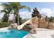 A stunning private pool features a rock slide and lush landscaping, perfect for relaxing and entertaining at 7554 Marker Ave, Kissimmee, FL 34747