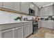 Modern kitchen with gray cabinets, white countertops, and stainless steel appliances at 1116 Hendon Loop, Davenport, FL 33837