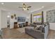 Bright living room featuring a sectional sofa, large TV, and wood-look flooring at 1116 Hendon Loop, Davenport, FL 33837