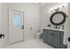 Modern bathroom featuring a vanity with gray cabinets, a round mirror, and updated fixtures at 17577 Davenport Rd, Winter Garden, FL 34787