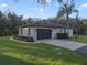 Attached garage with a dark gray door and landscaping at 17577 Davenport Rd, Winter Garden, FL 34787