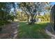 Landscaped side yard with detached garage and mature trees at 17577 Davenport Rd, Winter Garden, FL 34787