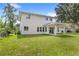 Wide view of the grassy backyard with a covered patio and white home exterior at 634 Burch Ave, Winter Garden, FL 34787