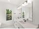 Bright bathroom with a dual-sink vanity, modern fixtures, and a serene garden view at 634 Burch Ave, Winter Garden, FL 34787
