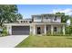 Well-maintained two-story home with stone pillars, modern garage door and lush green lawn at 634 Burch Ave, Winter Garden, FL 34787
