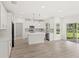Beautiful kitchen with white cabinets, a center island, and stainless steel appliances next to a door leading to a view of the lawn at 634 Burch Ave, Winter Garden, FL 34787