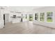 Bright, open-concept living room with modern white kitchen and large windows offering abundant natural light and scenic views at 634 Burch Ave, Winter Garden, FL 34787